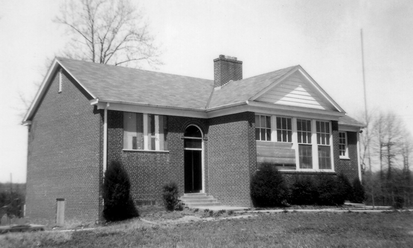 Black and white photograph of the Odrick’s Corner School. The windows are boarded up.